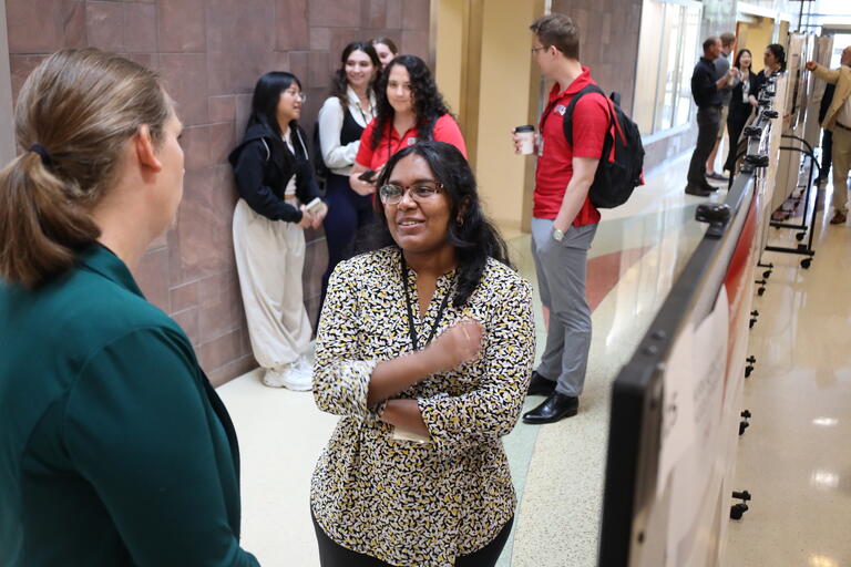 two women talking during symposium